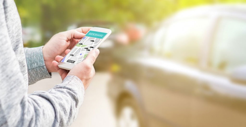 Véhicule de location disponible dans un parking dédié au libre-service, avec signalétique d'autopartage visible en arrière-plan